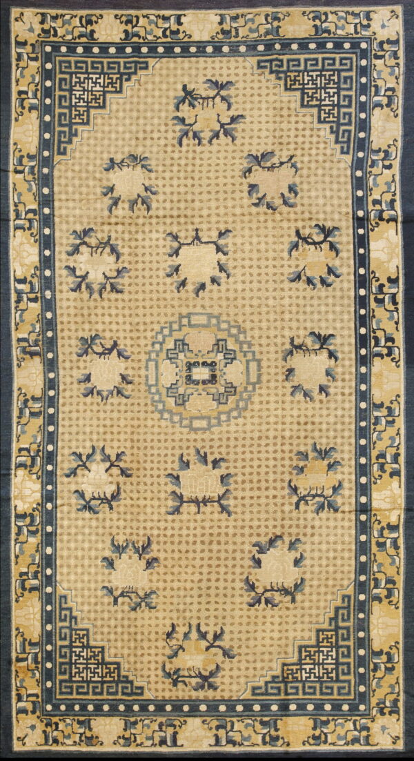 Beige rug with a dotted field, stylized blue floral clusters, and intricate geometric greek key borders.