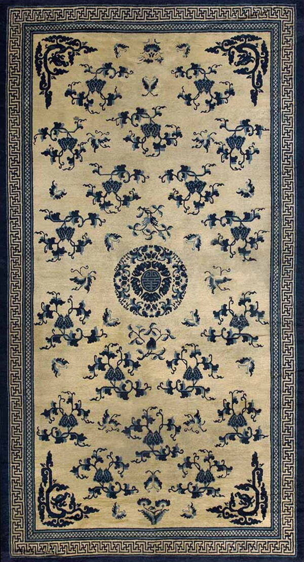 Cream and indigo rug featuring a dense floral vine pattern, central medallion, and geometric border.