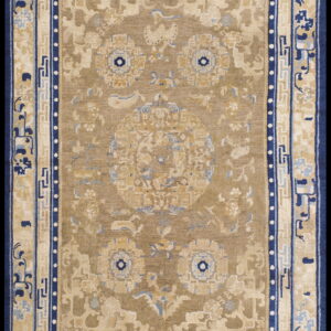 Tan and beige traditional rug featuring dark blue borders and ornate floral medallion patterns.