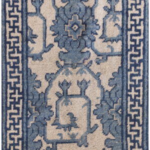 Blue and beige rug featuring stylized floral motifs and a Greek key geometric border.
