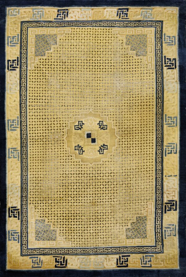 Gold rug with dense dot patterns and wide geometric borders in dark navy, light blue, and yellow.