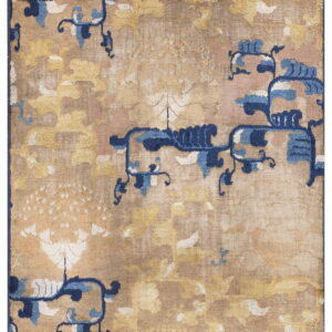 Tan rug with large, faded golden floral patterns and scattered dark and light blue stylized motifs.