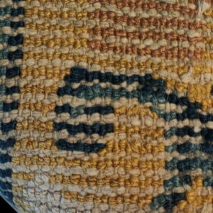 Detailed close-up of a chunky textured rug in horizontal bands of rust, yellow, cream, navy, and teal.