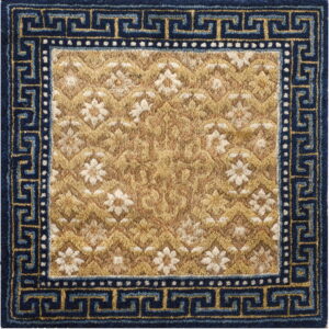Gold high-pile rug with cream flowers and a detailed navy blue border featuring a Greek key pattern.