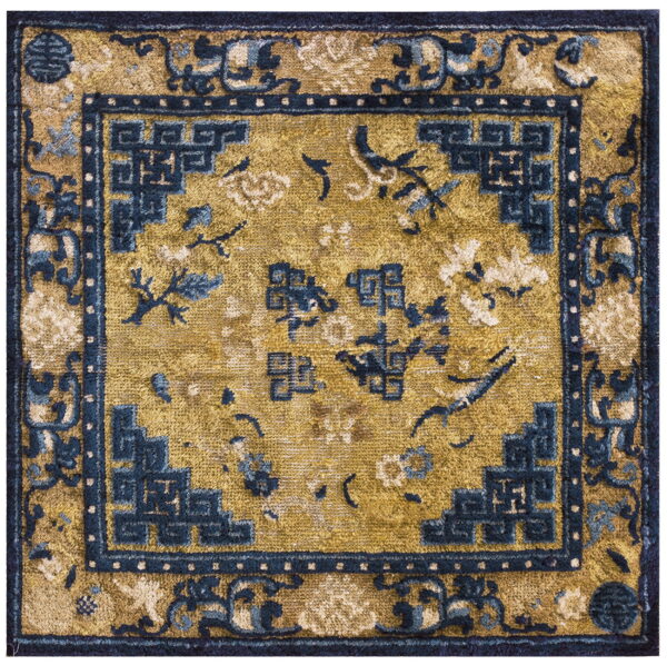 Mustard yellow square rug with dark blue stylized fretwork borders and floral and bird motifs.