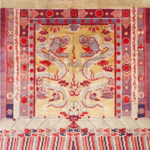 Gold rug with a symmetrical pattern of two stylized gray dragons and broad purple and red borders.
