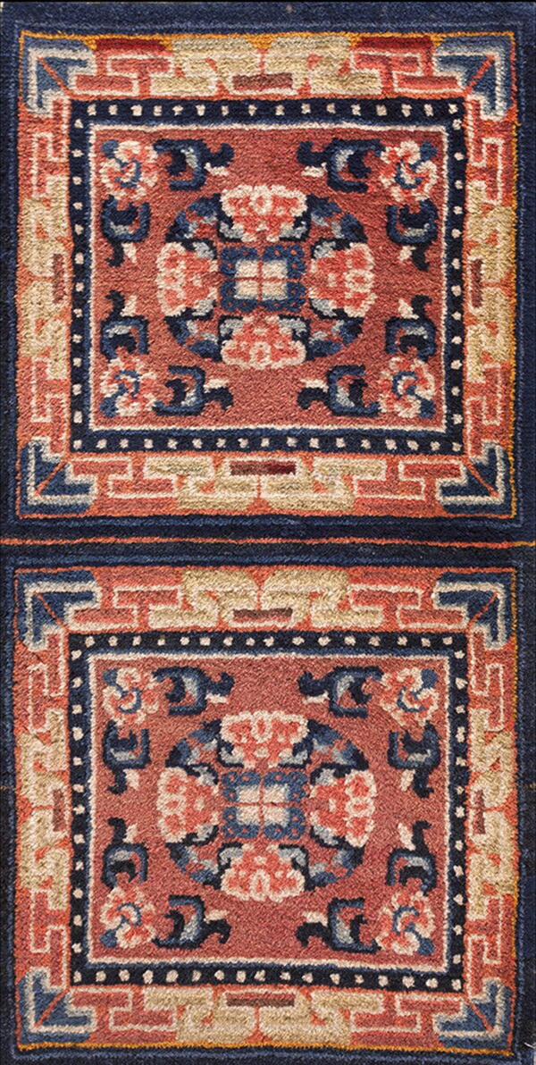 High-pile rug detail with repeating terracotta and navy panels surrounded by geometric borders.