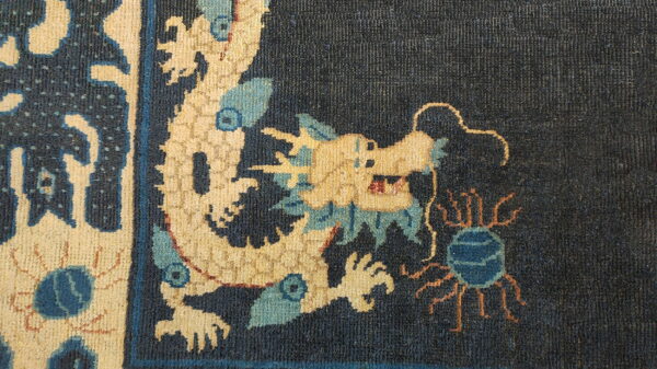 Antique chinese - ningxia hallway runner wool blue rug 3 Detailed corner of a high-pile rug showing a cream and blue dragon on a dark blue ground.