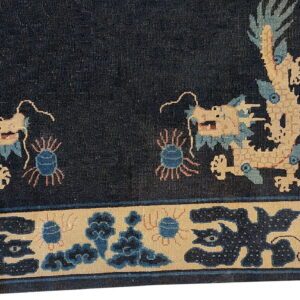 Dark blue rug detail showing two tan dragons facing a dark field and a detailed border.