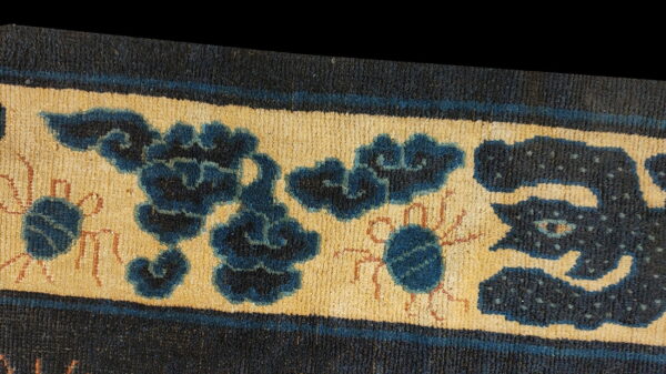 Antique chinese - ningxia hallway runner wool blue rug 6 Blue floral and stylized creature motifs decorate the tan border of a dense, low-pile rug.