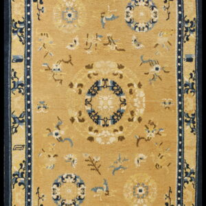 A rectangular gold rug with dark blue borders surrounding scattered floral motifs and circular medallions.