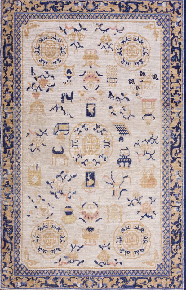 Cream rug with navy blue, tan, and light pink scattered motifs and a complex multi-layered border.