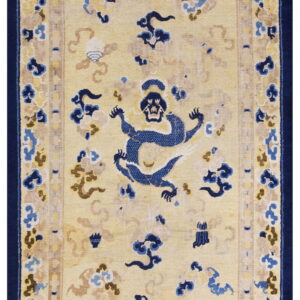 Pale yellow runner rug with a low pile features stylized blue dragon motifs and dark blue borders.