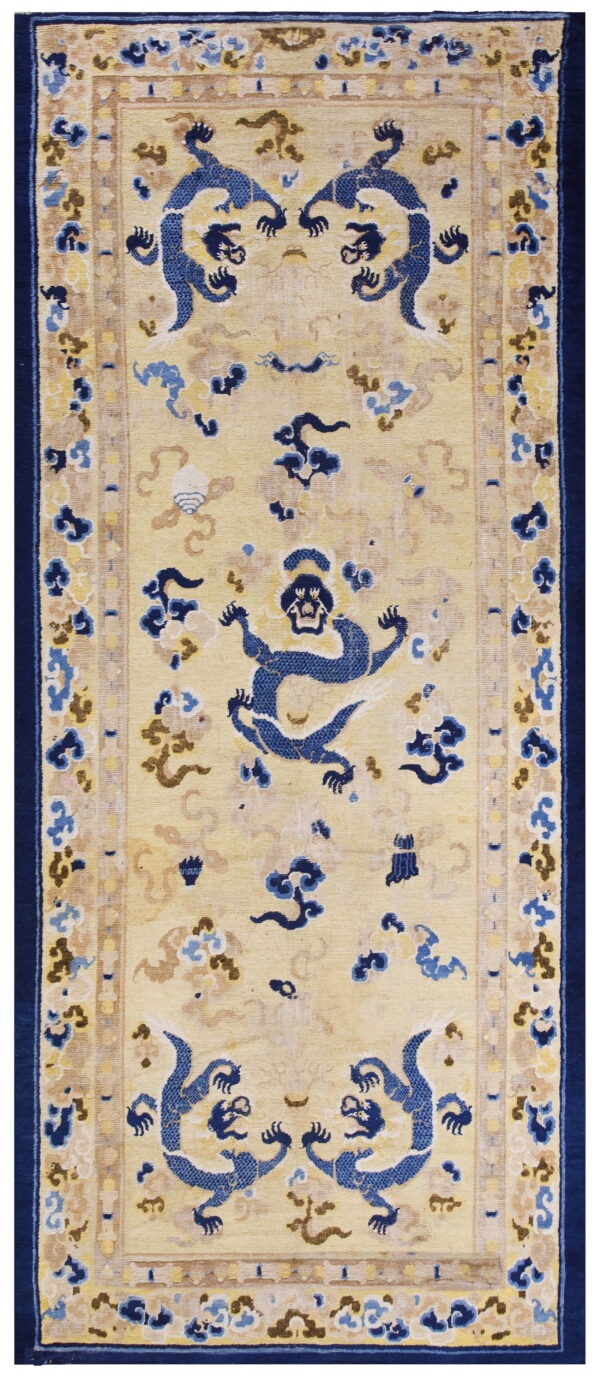Pale yellow runner rug with a low pile features stylized blue dragon motifs and dark blue borders.