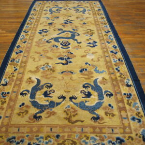 Mustard yellow runner rug featuring dark blue dragons and cloud patterns on hardwood planks.