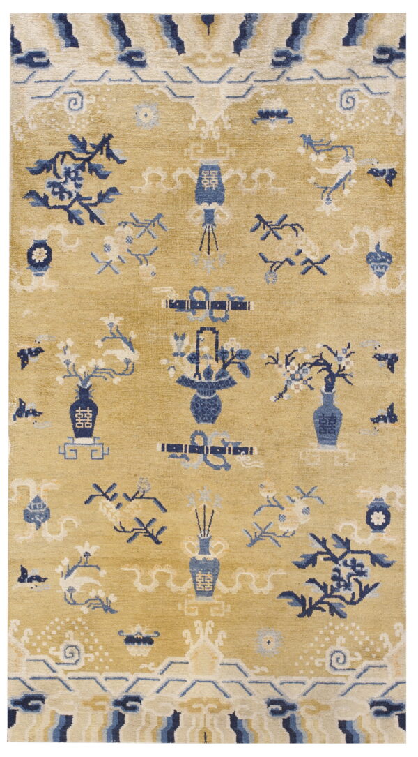 Golden yellow rug featuring dense blue and cream floral and decorative vase motifs.