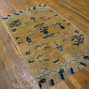Gold rug featuring scattered navy blue vases, lanterns, and floral designs on rustic hardwood planks.
