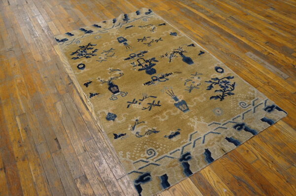 Gold rug featuring scattered navy blue vases, lanterns, and floral designs on rustic hardwood planks.