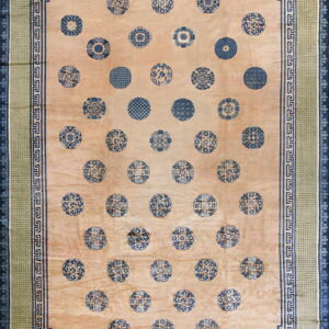 Beige rug with scattered blue medallions, framed by blue Greek key and green geometric borders.