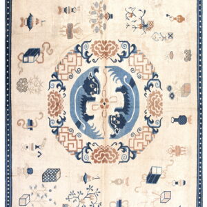 Ivory rug with dark blue border, featuring scattered objects and a central blue and tan medallion pattern.