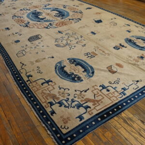 Low-pile beige rug with dark blue animal motifs, rusty brown details, and geometric borders on hardwood flooring.