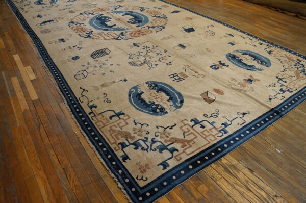 Low-pile beige rug with dark blue animal motifs, rusty brown details, and geometric borders on hardwood flooring.