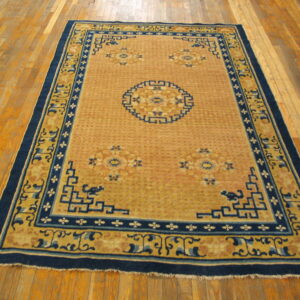Saffron and blue geometric rug with a detailed central medallion displayed on light hardwood planks.