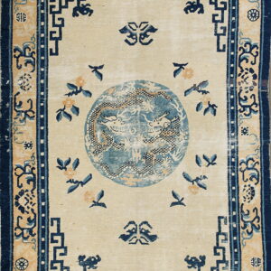 Cream rug with a central blue dragon medallion and repeating navy geometric key pattern border.