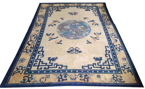 Ivory rug with indigo blue patterns, gold accents, and a central blue dragon medallion.