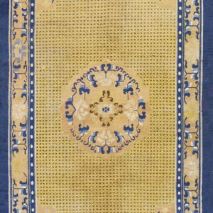 Yellow rug featuring a dark dotted field pattern, navy blue borders, and blue and white floral motifs.
