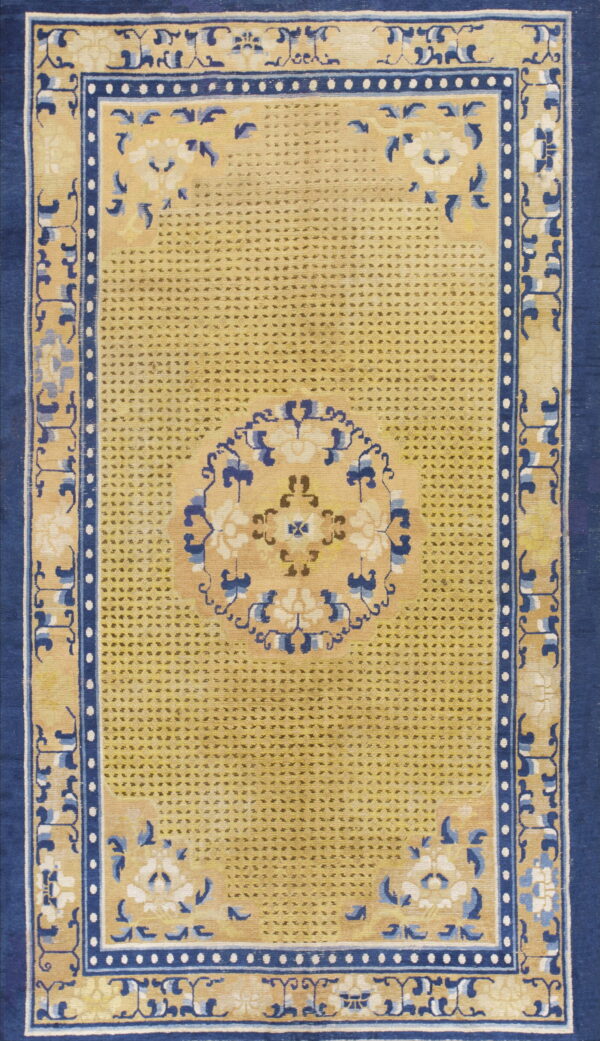 Yellow rug featuring a dark dotted field pattern, navy blue borders, and blue and white floral motifs.