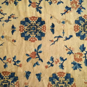 Cream rug with blue and terracotta floral and geometric patterns in a scattered layout.