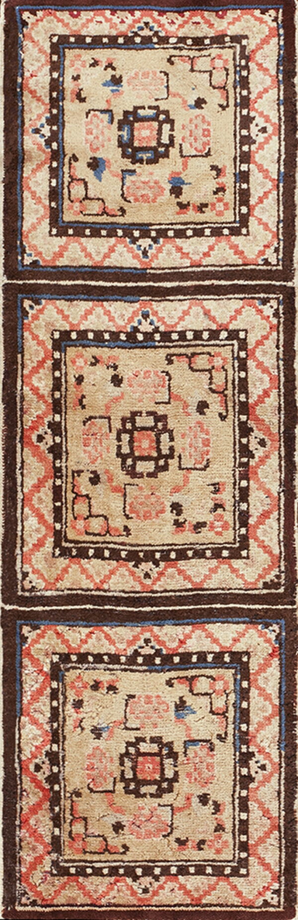 Tribal rug runner featuring light fields framed by dark brown borders and coral geometric patterns.