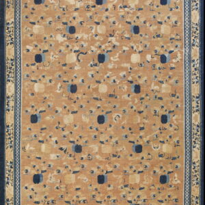 Tan rug featuring scattered stylized blue and cream patterns surrounded by layered ornate navy blue borders.