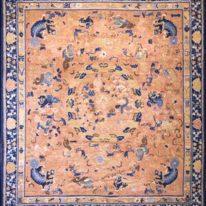 Peach field rug with blue mythical motifs and a wide, ornate navy blue floral border.