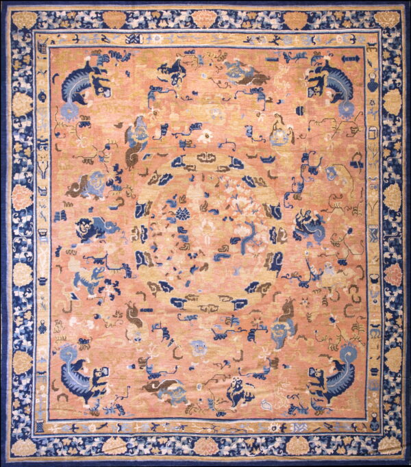 Peach field rug with blue mythical motifs and a wide, ornate navy blue floral border.