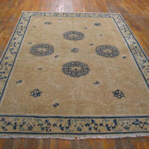 Low-pile tan rug with three central blue medallions and detailed floral borders on hardwood.