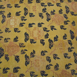 Gold rug with a dense pattern of dark blue stylized leaves and large subtle orange floral designs.