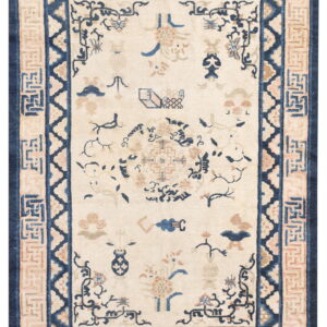 Ivory field rug featuring scattered motifs and multiple borders in deep blue and soft peach tones.
