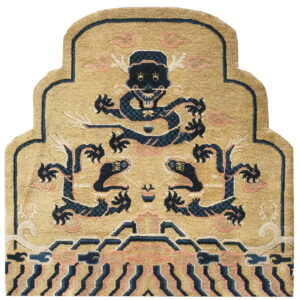 Gold and navy shaped rug with a high pile, showing a stylized mythical creature and pink cloud motifs.