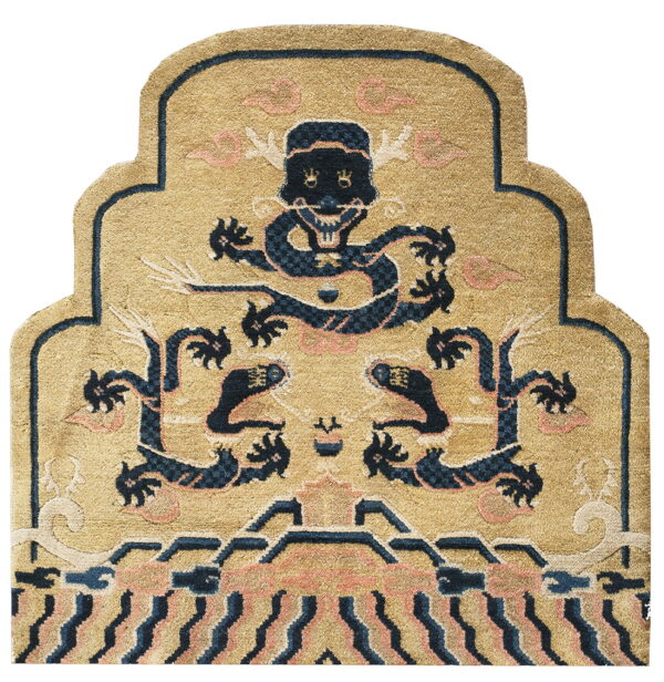 Gold and navy shaped rug with a high pile, showing a stylized mythical creature and pink cloud motifs.