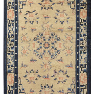 Beige area rug with a navy blue border and scattered floral patterns in light blue and pink.