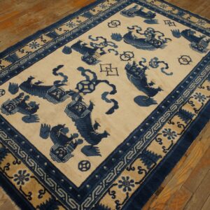 Deep blue and beige patterned rug with animal figures on rustic light brown wooden flooring.