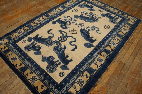 Deep blue and beige patterned rug with animal figures on rustic light brown wooden flooring.