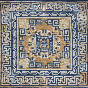 A square rug detail shows a high pile blue and tan geometric pattern with intricate fretwork borders.