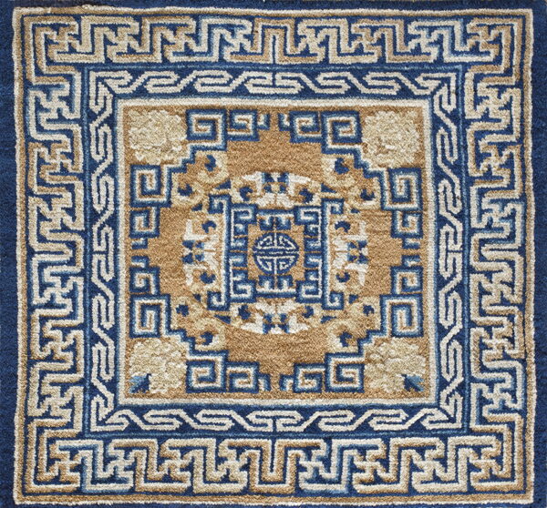 A square rug detail shows a high pile blue and tan geometric pattern with intricate fretwork borders.
