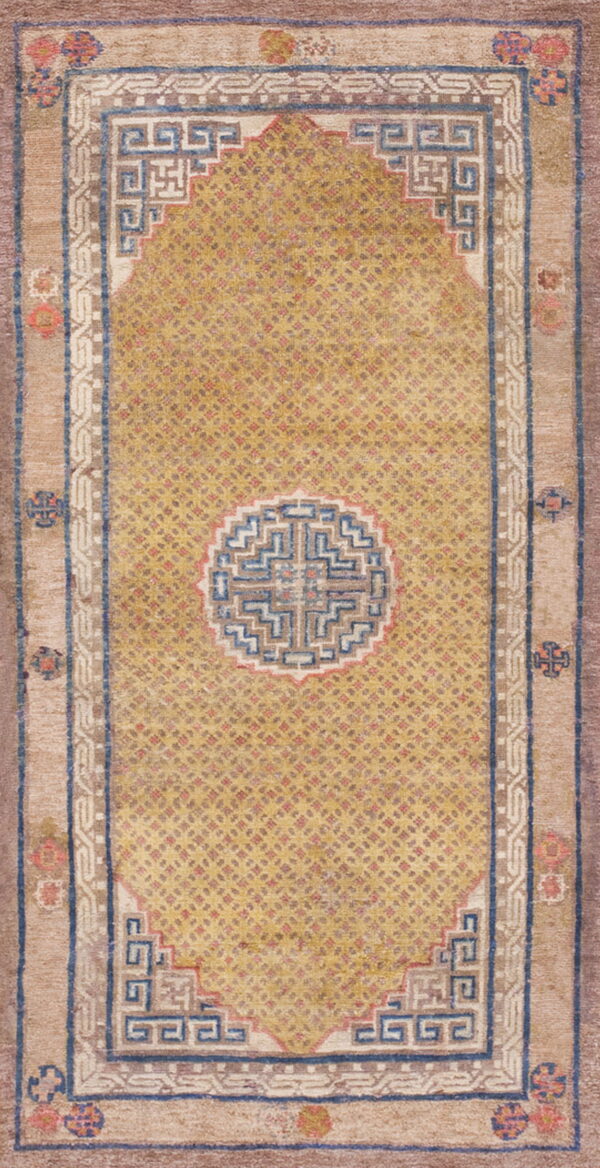 Gold field rug with a circular geometric medallion and angular blue-and-tan stepped borders.