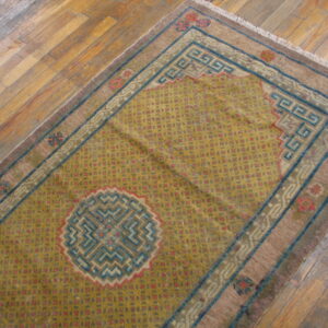 Yellow runner rug featuring geometric red dots, blue Greek key borders, and a central medallion on wood.