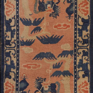 Rectangular rug with a coral field featuring stylized indigo animals and clouds, framed by a wide beige and blue border.
