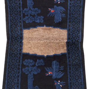 Black runner rug with dark blue animal and tree motifs, geometric borders, and a tan horizontal stripe.